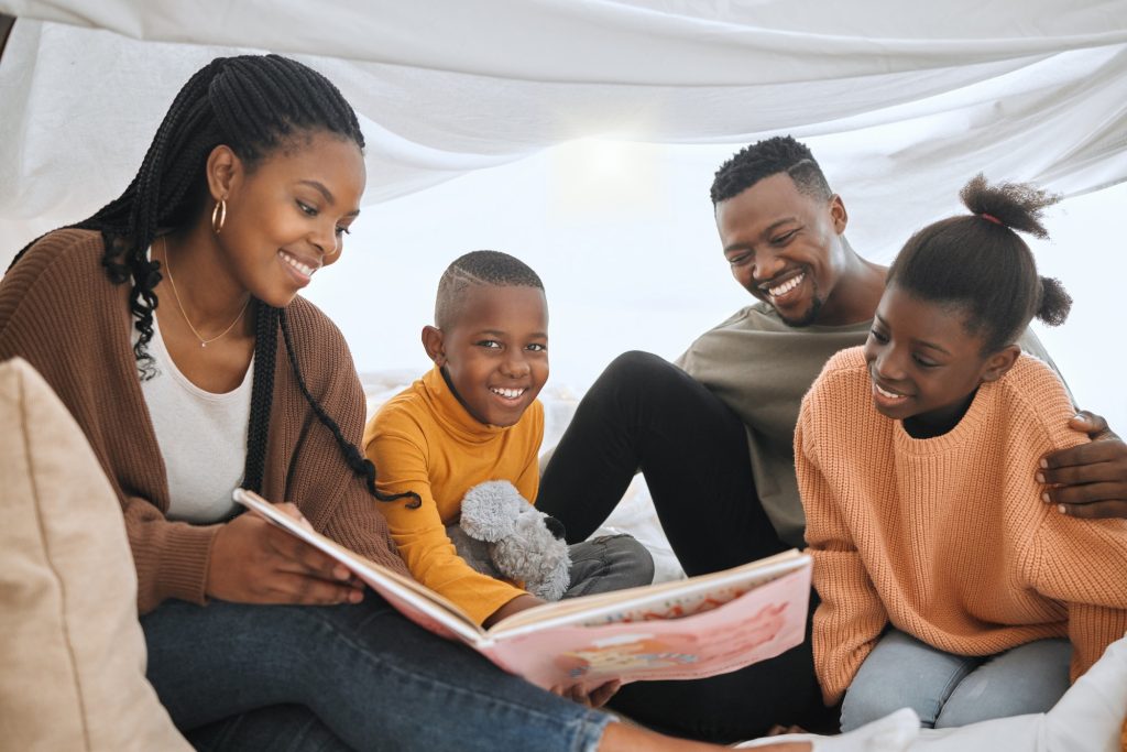 Is this still your favourite story. Shot of a young family reading a story together.